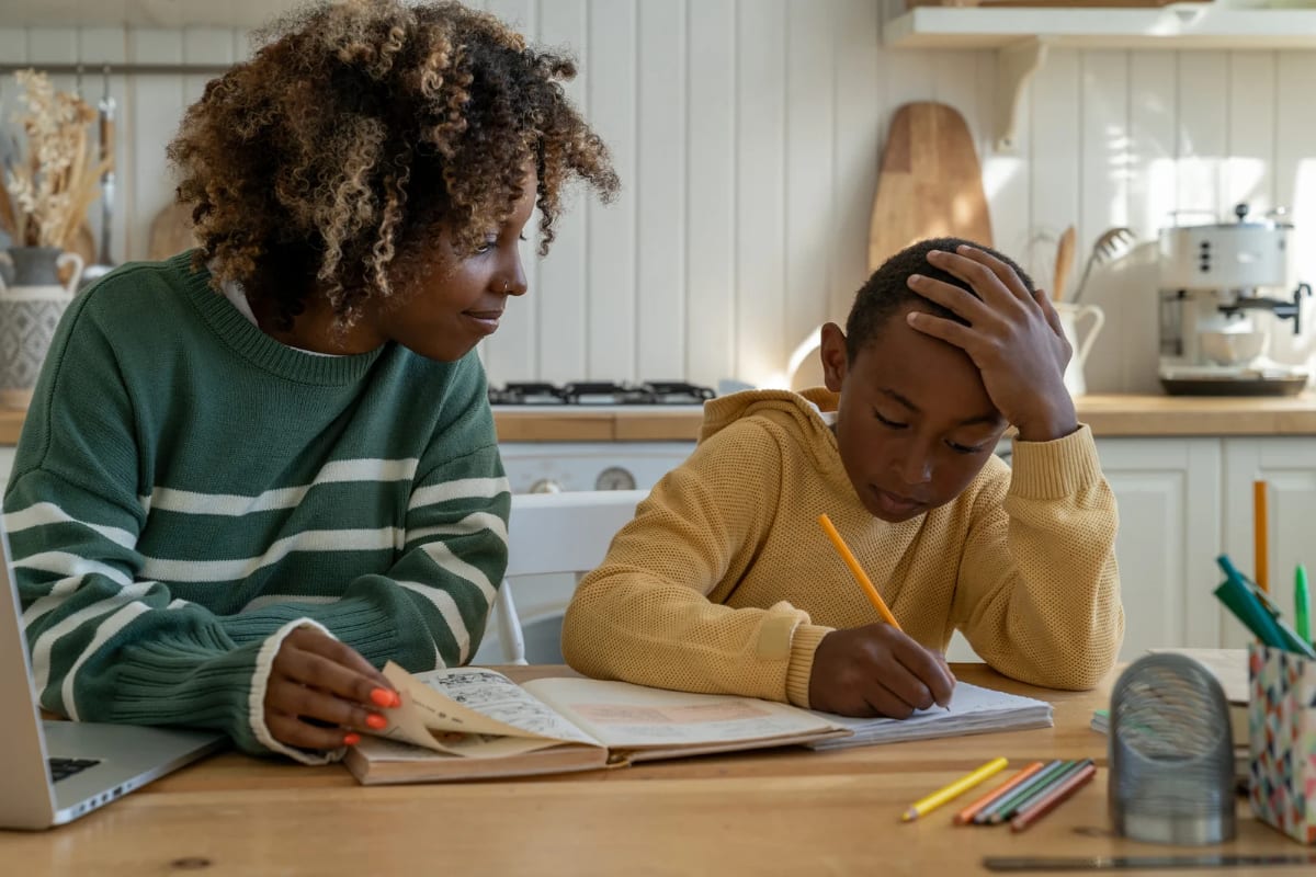 A parent supporting their child with schoolwork at home